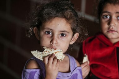 © WFP/Ali Jadallah A little girl eating bread