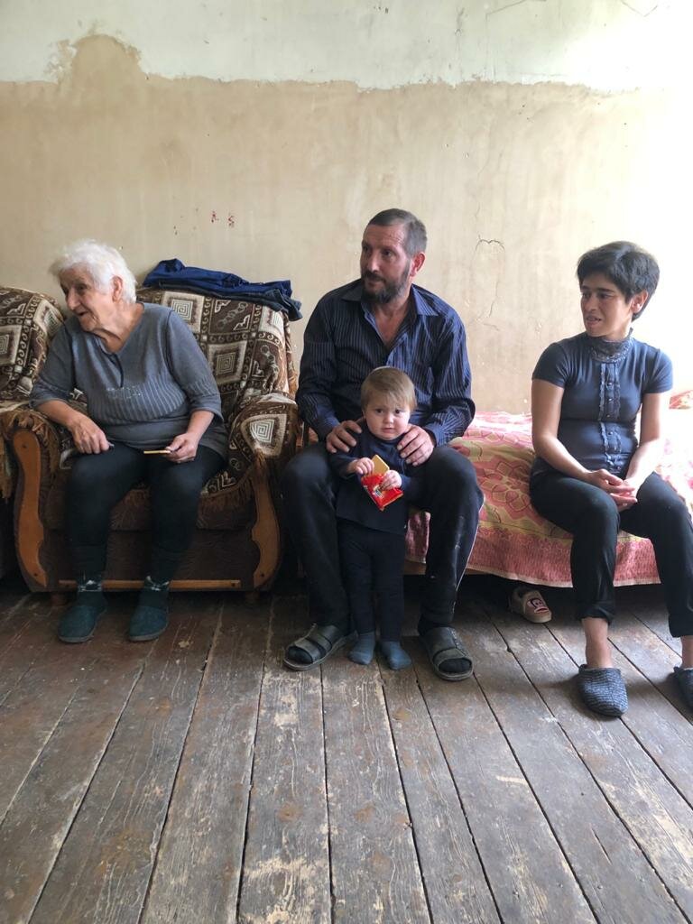 Vanush sitting in the middle of his mother and his wife with his youngest child Razmik