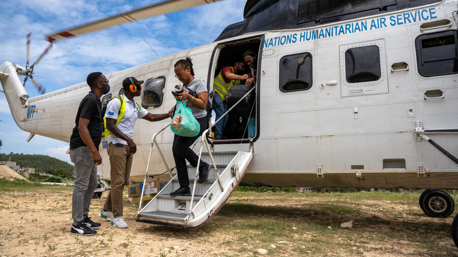 Passengers disembark from an UNHAS helicopter at Port-au-Prince. With commercial flights at Haiti's capital suspended, the WFP-run air service is more vital than ever. WFP/Pedro Rodrigues 