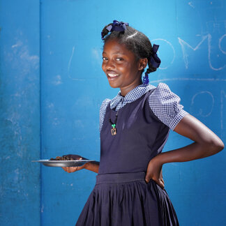 A school girl is holding a plate