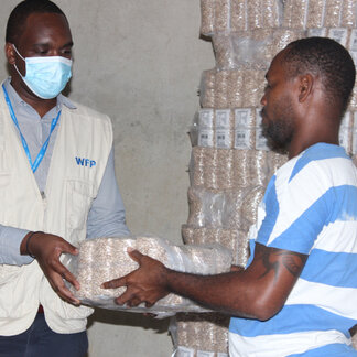 School director receiving food from the WFP to cook for children on school days. Photo:WFP/Jorcilina Correia