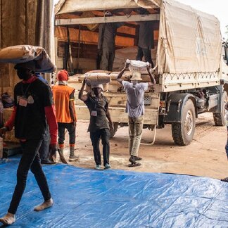 Workers at the warehouse transport bags of food supply to distribute to people in need in Kasai province, DR Congo.
