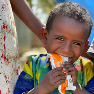 Boy eating nutrient-rich snack provided by WFP to treat malnutrition in Ethiopia