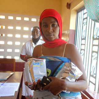 Woman receiving nutritious food distributed by WFP in Popodara health centre, Labe Guinea