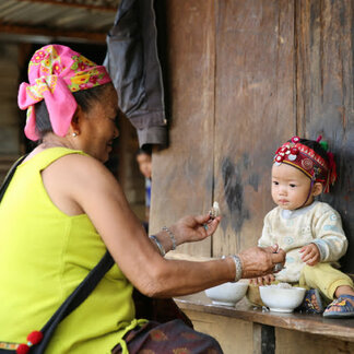 Mother feeding her child nutritious food provided by WFP