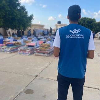 Rear view of man looking at supplies on ground