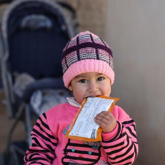 Dana, 22 months old, eating Plumpy'Sup provided by WFP. Photo: © WFP/Hussam Al Saleh.