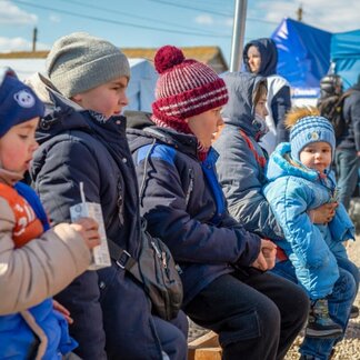 Group of children sitting in a food distribution center