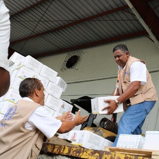 Two WFP employees load boxes of Super Cereal Plus in a truck for its distribution to vulnerable people in May 2018. Photo: WFP/Marcelle Rodriguez
