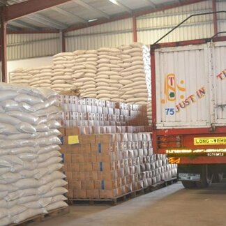 A truck in a warehouse stacked with boxes and bags of food