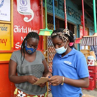 Two women looking at their mobile. Photo: WFP/Alice Ramoun