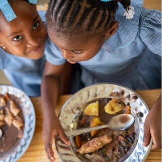 School girls enjoying nutritious school meal with local vegetables. Photo: WFP/Theresa Piorr