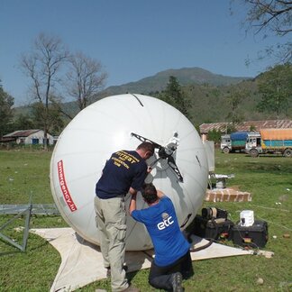 Two staff setting up telecommunications equipment