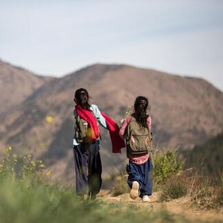 Two girls walking on road