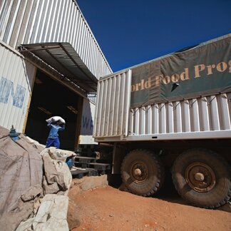 Man carrying bags of relief supplies to a truck